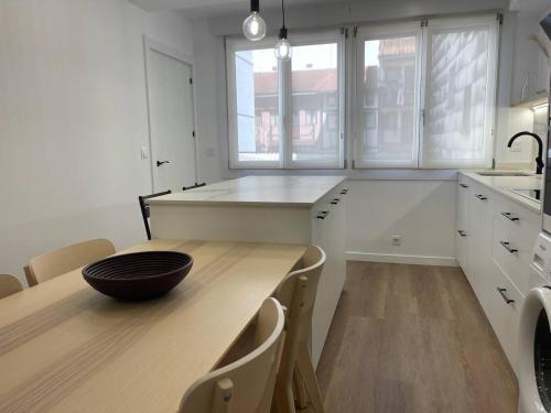 una cucina con tavolo in legno e ciotola di Bidebarrieta Etxea , apartamento recién reformado a Bermeo