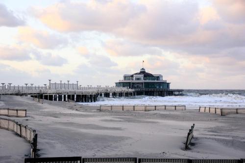 a pier on the beach with the ocean at Apartment Thalassa in Blankenberge