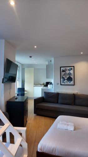 a living room with a black couch and a kitchen at Leicester Soho Piccadilly For 7 VR15 in London