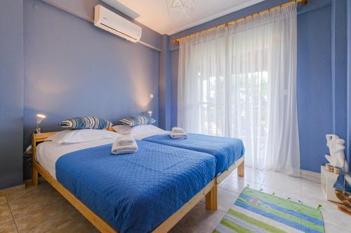 a blue bedroom with a bed and a window at IOLI by halu! 3BD family house with private garden in Afitos
