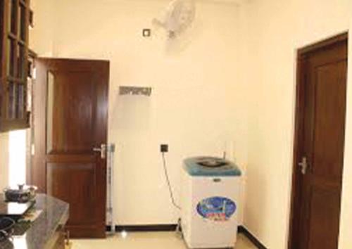 a kitchen with a refrigerator in the corner of a room at Cinnamon Edge in Mihiripenne
