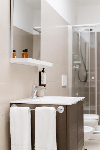 a bathroom with a sink and a shower with towels at Dieci by Comorooms in Como