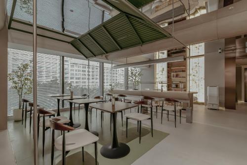 a restaurant with tables and chairs and windows at KSpace KaiShi hotel in Guangzhou
