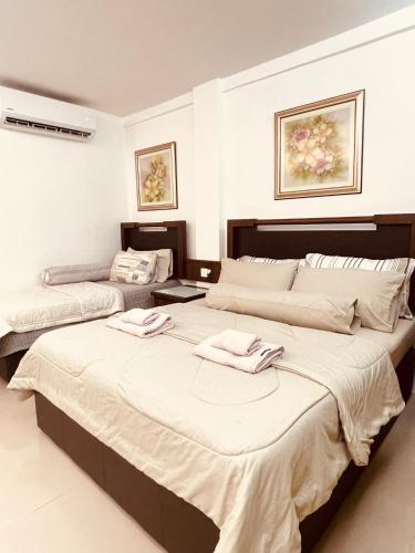 a bedroom with two beds with towels on them at Wan Studiostay by Khalifa Suites in Kota Bharu