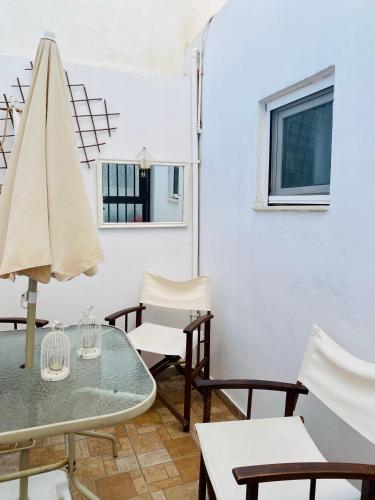 a patio with a table and chairs and a umbrella at Ermoupolis Traditional Townhouse in Ermoupoli