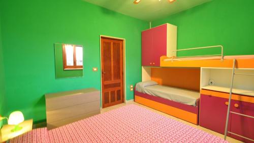 a green room with two bunk beds and a mirror at Villetta Giulia by Salento Affitti in Torre San Giovanni Ugento