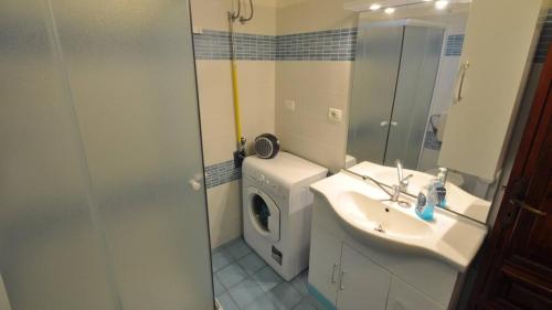 a bathroom with a sink and a washing machine at Villetta Giulia by Salento Affitti in Torre San Giovanni Ugento