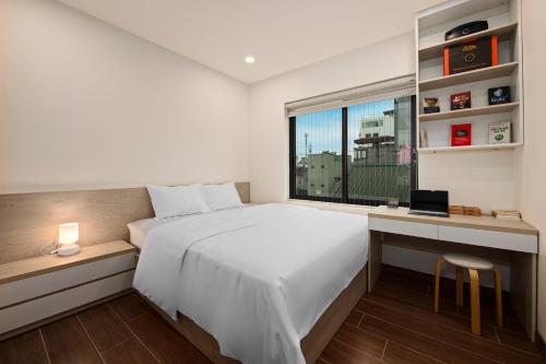 a bedroom with a bed and a desk and a window at The Literature'N Central Hotel and Travel Ha Noi 177 in Hanoi