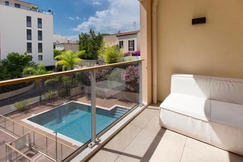 - un balcon avec une piscine au-dessus d'un bâtiment dans l'établissement 2 pièces avec clim, terrasse, piscine, 100m plage, à Cannes