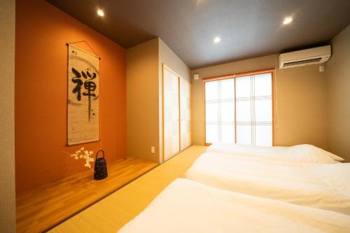 a bedroom with two beds and a window at Hisaya-Totoya-A in Kyoto