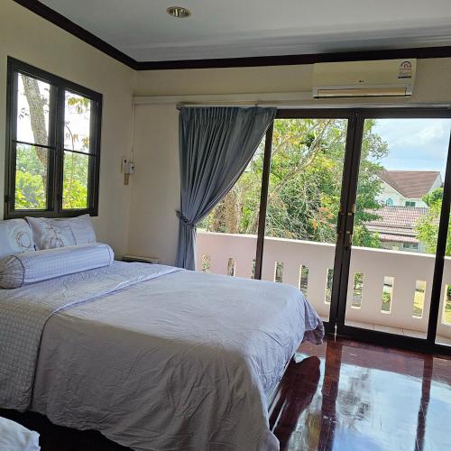 Ban Tha KupにあるWooden house and birdsong2のベッドと大きな窓のある寝室