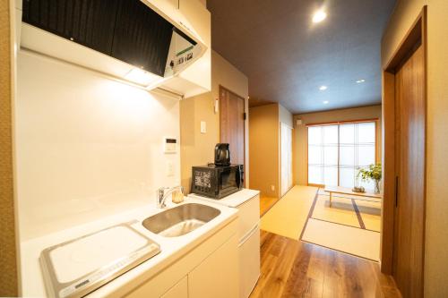 a kitchen with a sink and a microwave at Hisaya-Totoya-A in Kyoto