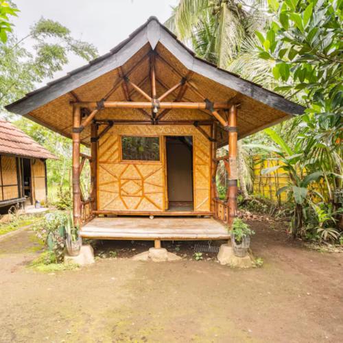 a small house with a porch in a forest at Pondok Inggris Homestay in Seganteng