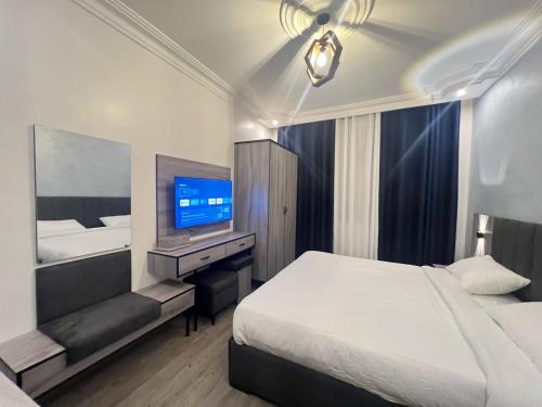 a hotel room with a bed and a television at Nabatean Hearth Guest House in Taiyiba