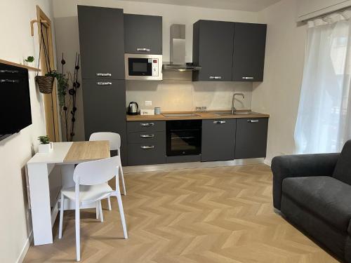a living room with a table and a kitchen at BloomHouse - apartment in Porlezza
