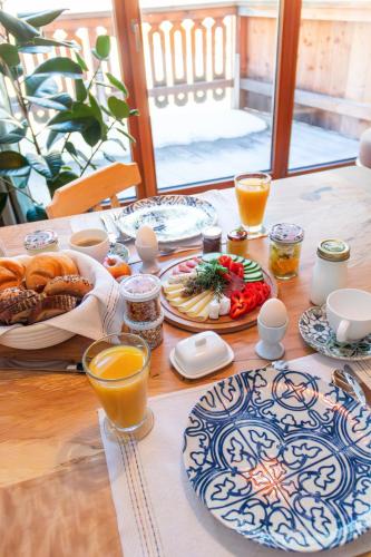 a table with breakfast foods and orange juice on it at Ecologie Grundlsee in Grundlsee