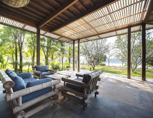 a living room with a couch and a table and chairs at Nachan The Antique Courtyard in Chiang Khan