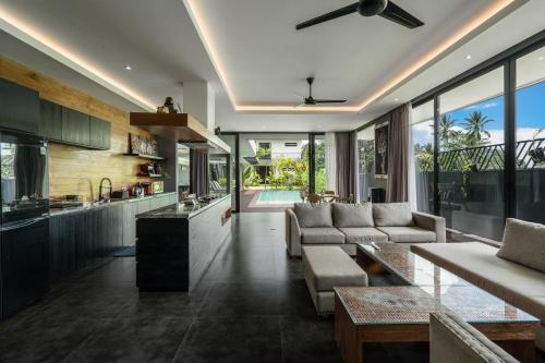 a kitchen and living room with a couch and a table at Villa Zilla by BaliSuperHost in Tegalalang
