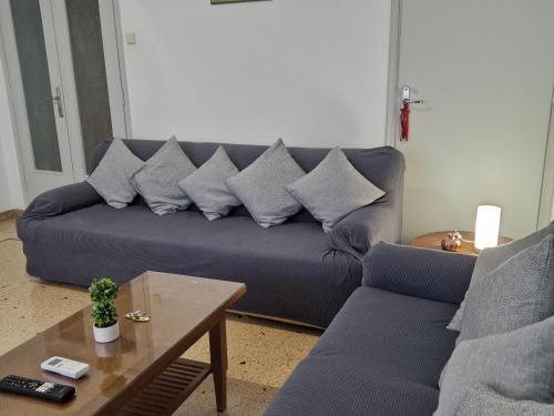 a living room with a blue couch with pillows at EstellApartments in Athens