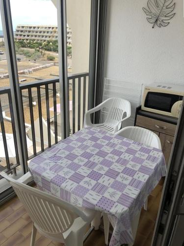 d'une table et de deux chaises sur un balcon avec une table et une table. dans l'établissement Studio Héliopolis F 74- 2 personnes, au Cap d'Agde