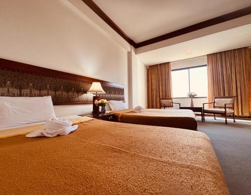 a hotel room with two beds and a window at Royal Mekong Riverside Hotel in Nong Khai