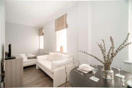 a white living room with a white couch and a table at Modern Studio Apartment in Waterloo Liverpool in Liverpool