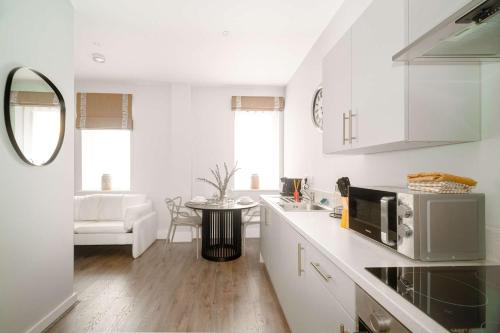 a kitchen with white cabinets and a counter top at Modern Studio Apartment in Waterloo Liverpool in Liverpool