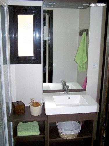 une salle de bain avec un lavabo blanc et un miroir dans l'établissement Cottage climatisé, piscine, nature, à Solliès-Toucas