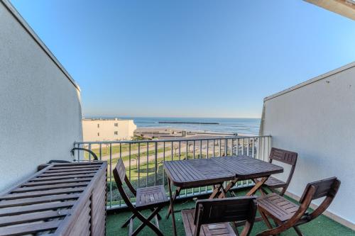 un balcon avec une table et des chaises et l'océan dans l'établissement Appartement vue mer et Parking, à Palavas-les-Flots