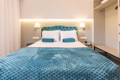 a bedroom with a large blue bed with two pillows at Anna Studio in Amoudara Herakliou