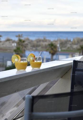 deux verres de jus d'orange assis sur un livre dans l'établissement Studio LIBERTINE - Héliopolis L 82 - Luxe - 2 personnes, au Cap d'Agde