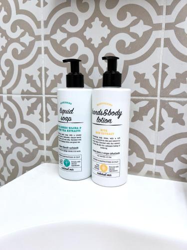 two bottles of moisturizers sitting on a shelf in a bathroom at Mercadante Suite Central City in Milan