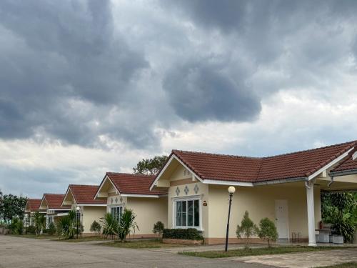 a row of houses with brown roofs on a street at Aivarata Resort in Ban Phra Trong