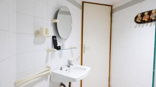 a bathroom with a sink and a mirror at Extra Spacious and Homey 2BR at Kondominium Puncak Marina Apartment By Travelio in Surabaya