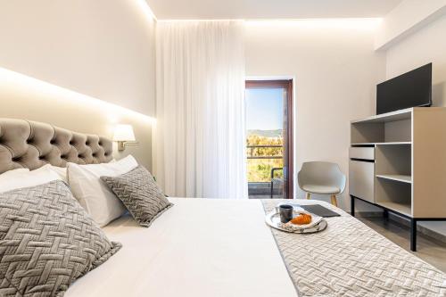 a white bedroom with a bed and a window at Anna Studio in Amoudara Herakliou