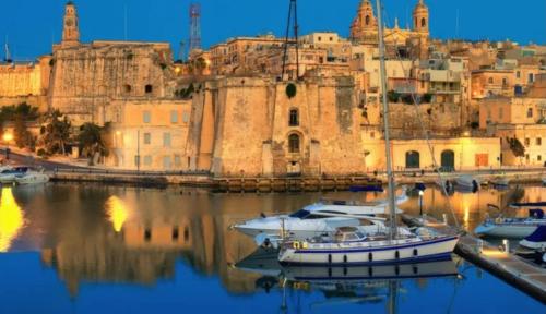 a group of boats in a harbor with a city at Charming town house in Cospicua, Valperga Rooms in Cospicua