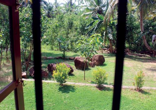 a view of a garden from a window at Cinnamon Edge in Mihiripenne