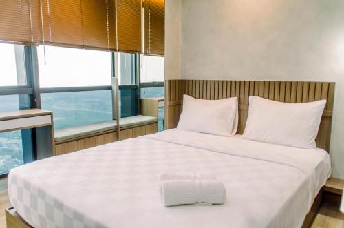 Кровать или кровати в номере Elegant and Nice 1BR at The Smith Alam Sutera Apartment By Travelio