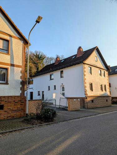 a white building on the side of a street at Casita im Tal - Entspannung mit Terrasse, Garten und Garage in Weilburg