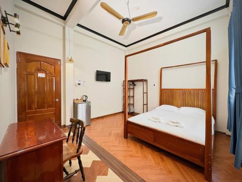 a bedroom with a bed and a desk and a table at BÊ TÔNG RESIDENCES HOMESTAY in Can Tho