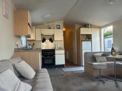 a living room with a couch and a kitchen at Seaside Stay in Port Carlisle