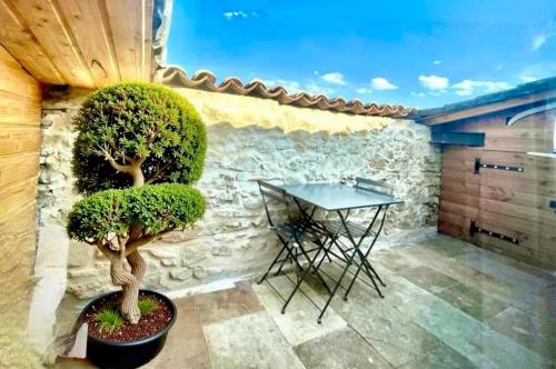 a patio with a table and trees in a room at La Tropézienne, charme et confort au coeur du Gard in Saint-Géniès-de-Malgoirès