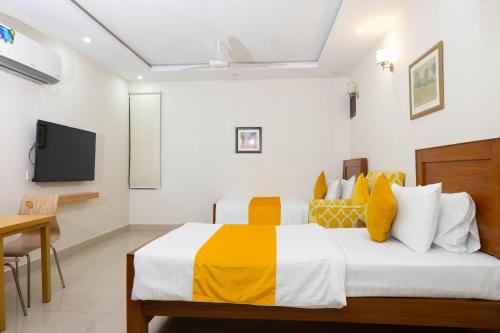 a bedroom with a bed and a tv on the wall at Maati Spaces - Rooms with Kitchen in Lahore