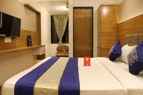 a hotel room with a large bed with blue pillows at Aqua City Hotel in Panjim in Panaji