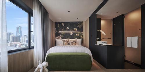 a bedroom with a bed and a large window at PARKROYAL COLLECTION Kuala Lumpur in Kuala Lumpur