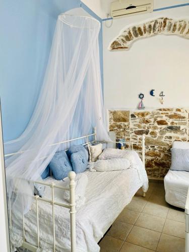 a bedroom with a white bed with a canopy at Ermoupolis Traditional Townhouse in Ermoupoli