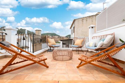a patio with chairs and tables on a balcony at Casa La Roca in Pollença