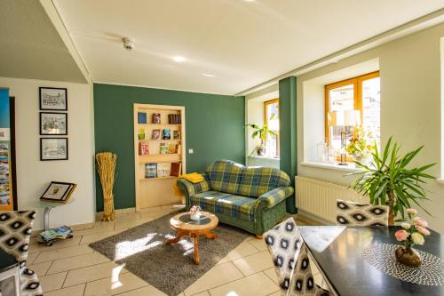 a living room with a couch and a table at Erzgebirgshotel Freiberger Höhe in Eppendorf