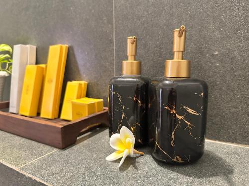 two bottles of soap and a flower on a counter at Santa Maria - A Premium Boutique Homestay by the Sea I Trivandrum Airport 1mile in Trivandrum