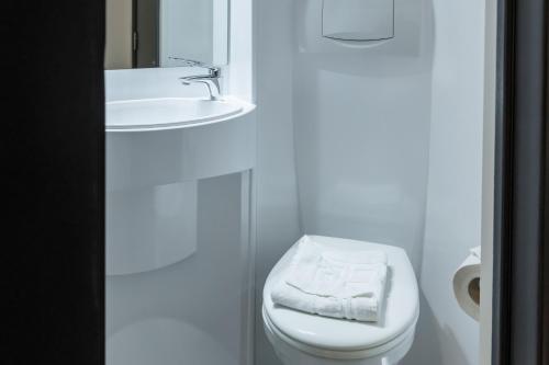 a bathroom with a white toilet and a sink at easyHotel Victoria in London